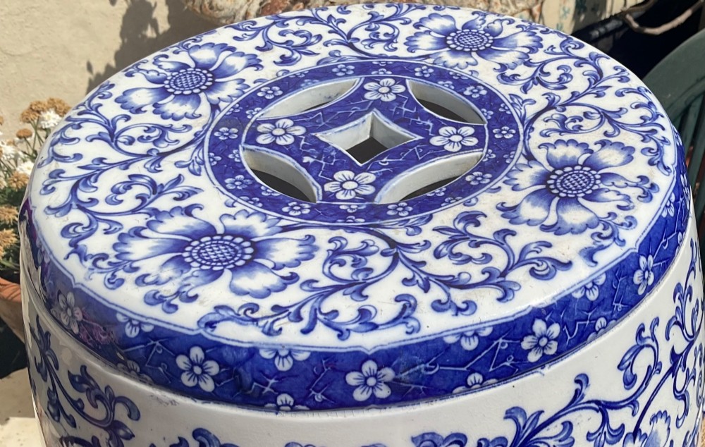 A Victorian barrel-shaped ceramic garden seat decorated with blue floral patterns on a white background and featuring a central band of intertwined openwork rings. View III
