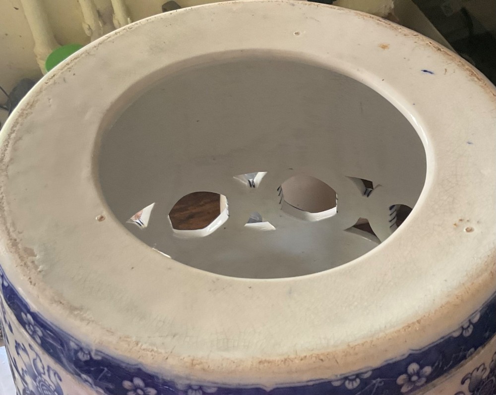 A Victorian barrel-shaped ceramic garden seat decorated with blue floral patterns on a white background and featuring a central band of intertwined openwork rings. View IV