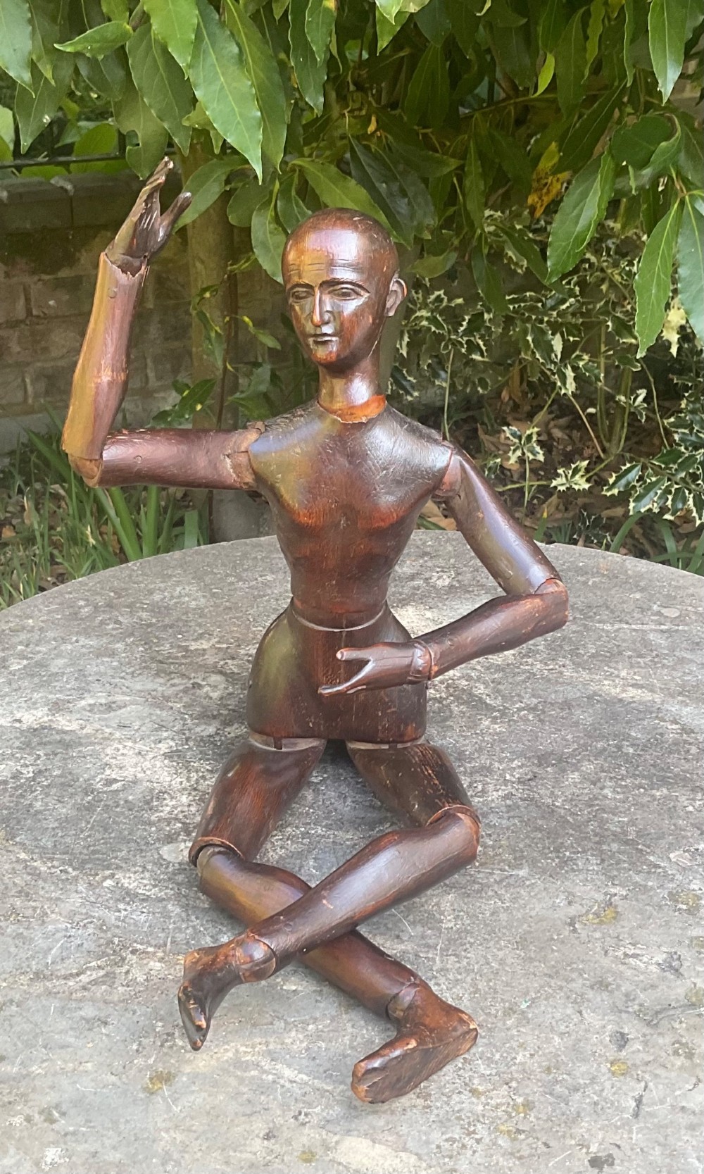 A nineteenth-century articulated carved dark wood artists lay figure seated with crossed legs and posed arms.