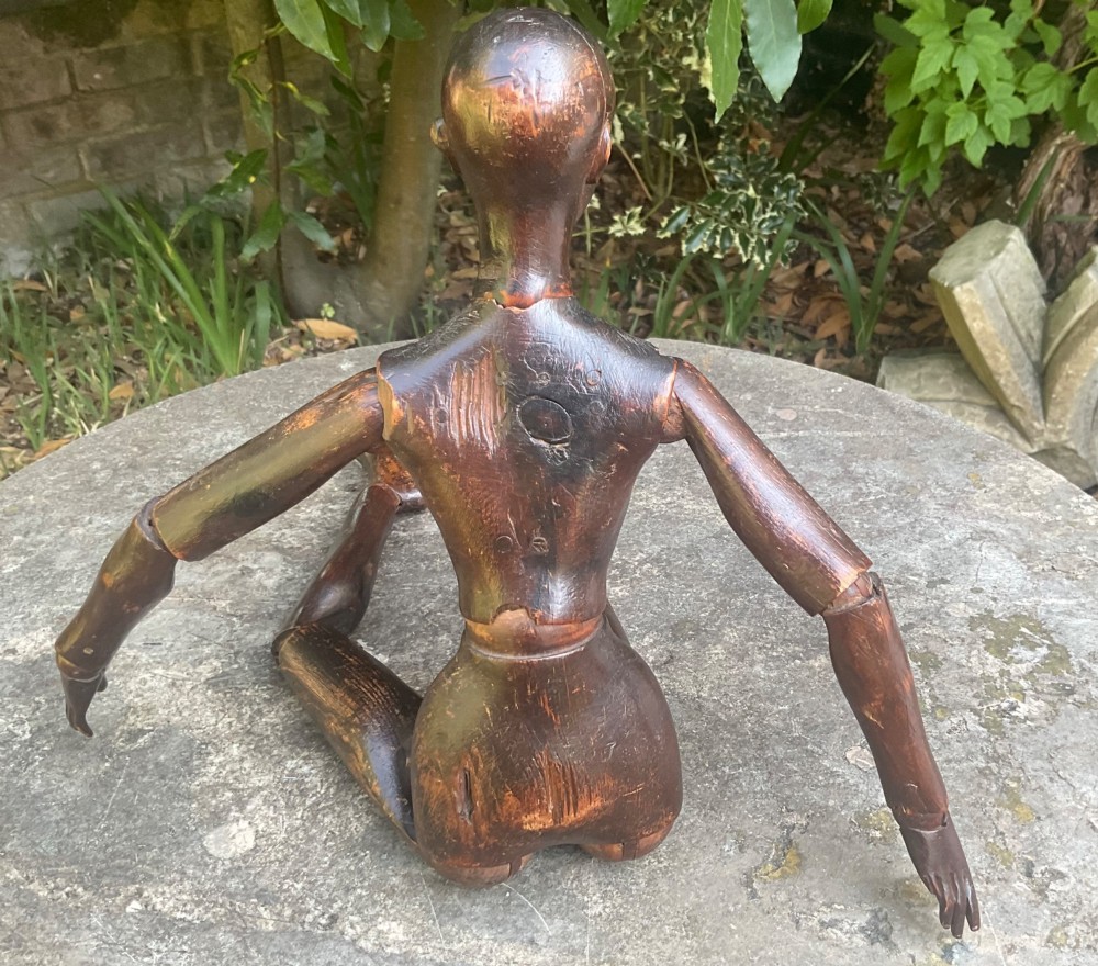 A nineteenth-century articulated carved dark wood artists lay figure seated with crossed legs and posed arms. View VII