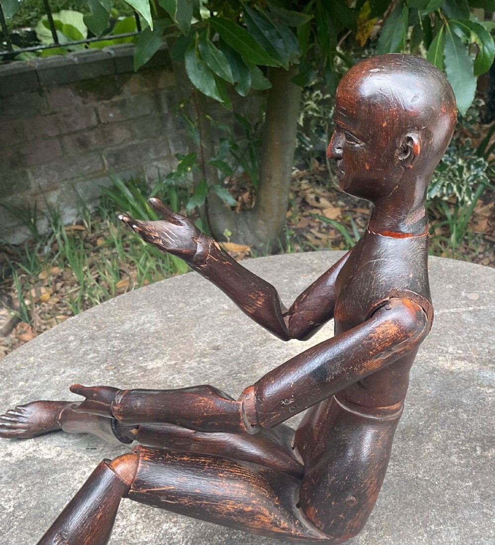 A nineteenth-century articulated carved dark wood artists lay figure seated with crossed legs and posed arms. View XII