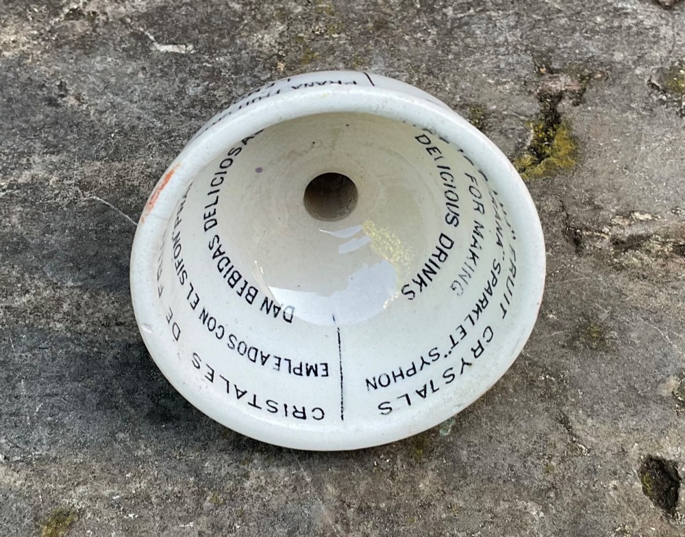 A cream glazed ceramic funnel printed with black Edwardian commercial typography for Prana Fruit Crystals. View IV