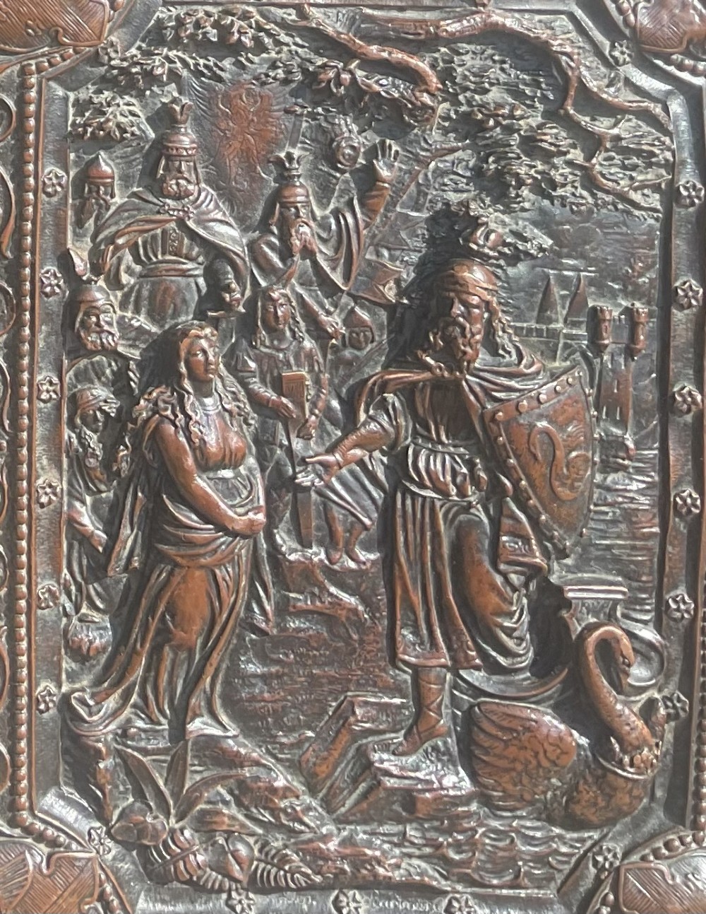 An antique brown leather desk blotter featuring a central embossed copper relief panel depicting a scene from Wagners opera Lohengrin with a knight and swan. View II