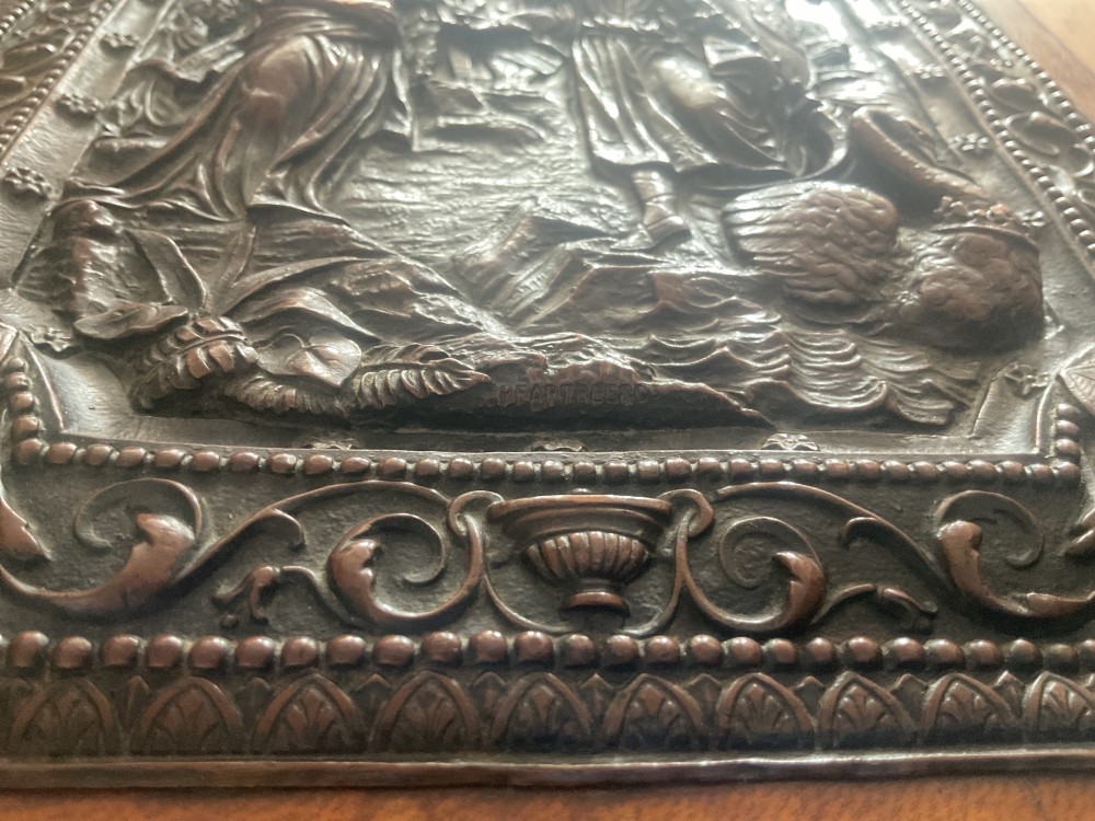 An antique brown leather desk blotter featuring a central embossed copper relief panel depicting a scene from Wagners opera Lohengrin with a knight and swan. View V