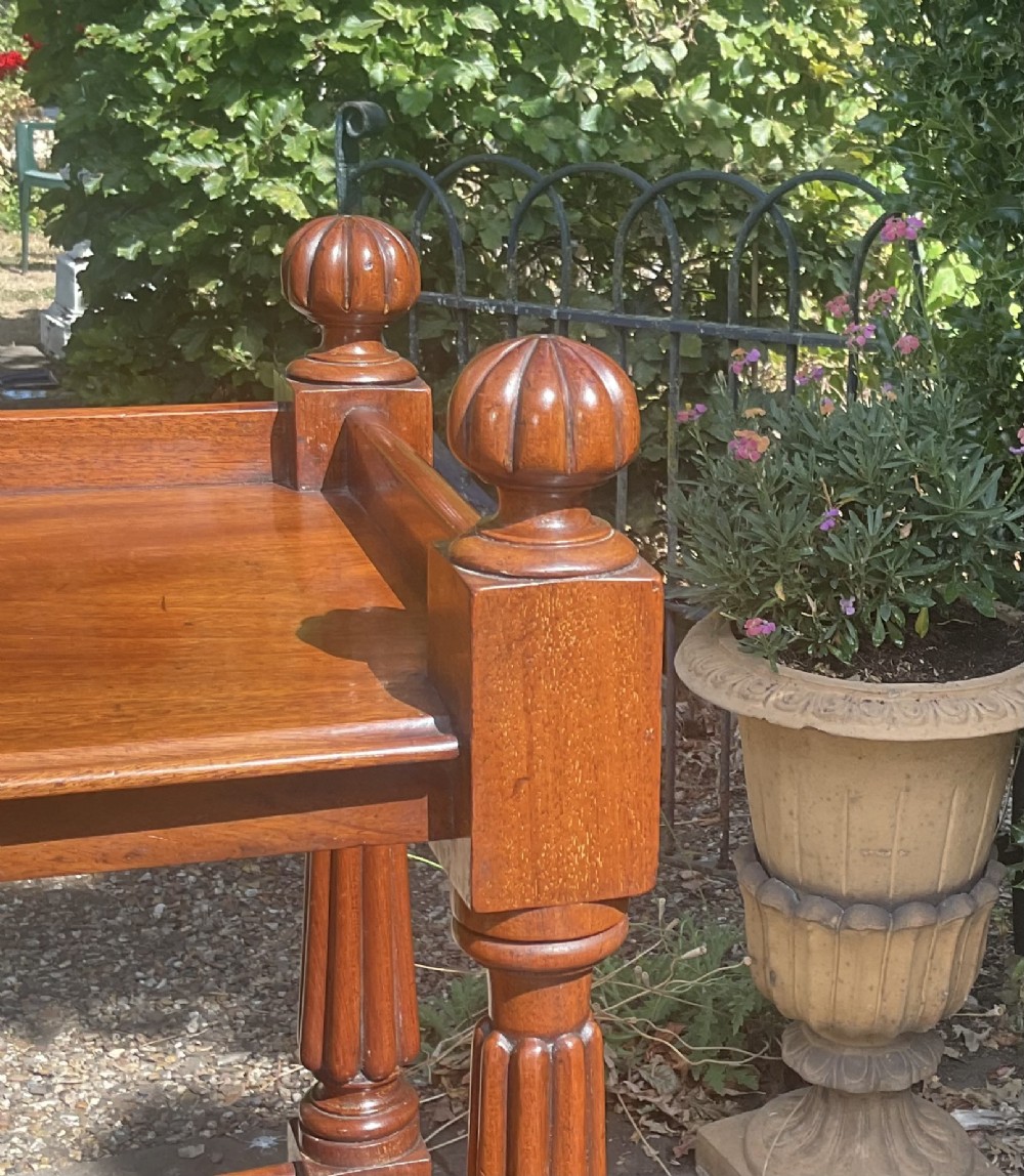 A Victorian mahogany three-tier etagere featuring reeded vertical supports, turned finials, and gallery rimmed shelves. View IV