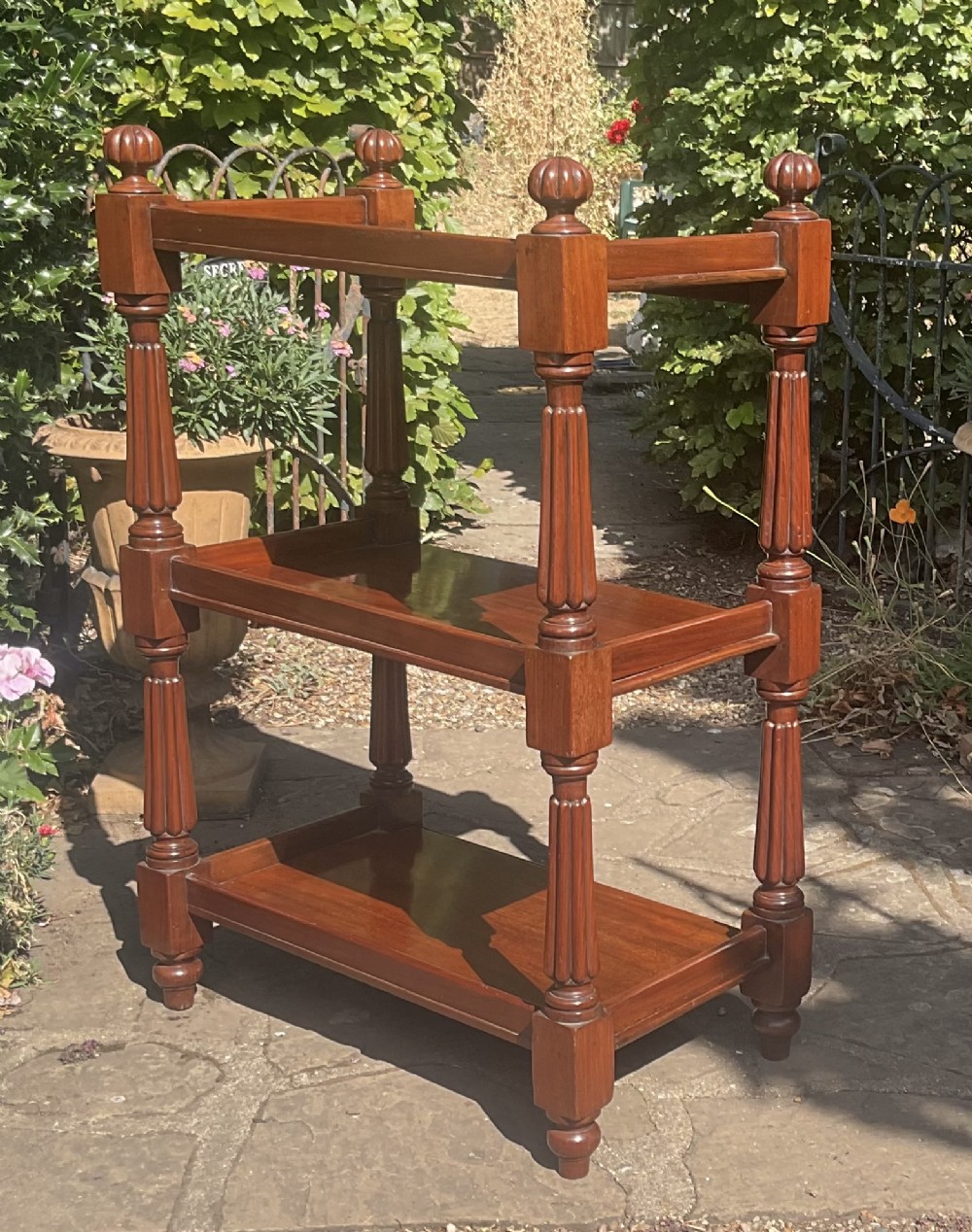 A Victorian mahogany three-tier etagere featuring reeded vertical supports, turned finials, and gallery rimmed shelves. View V