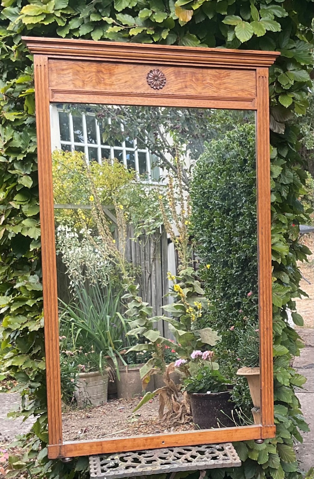 A rectangular Edwardian blonde oak mirror featuring a moulded cornice top, central carved rosette motif, fluted side pilasters, and a clear glass plate. View III