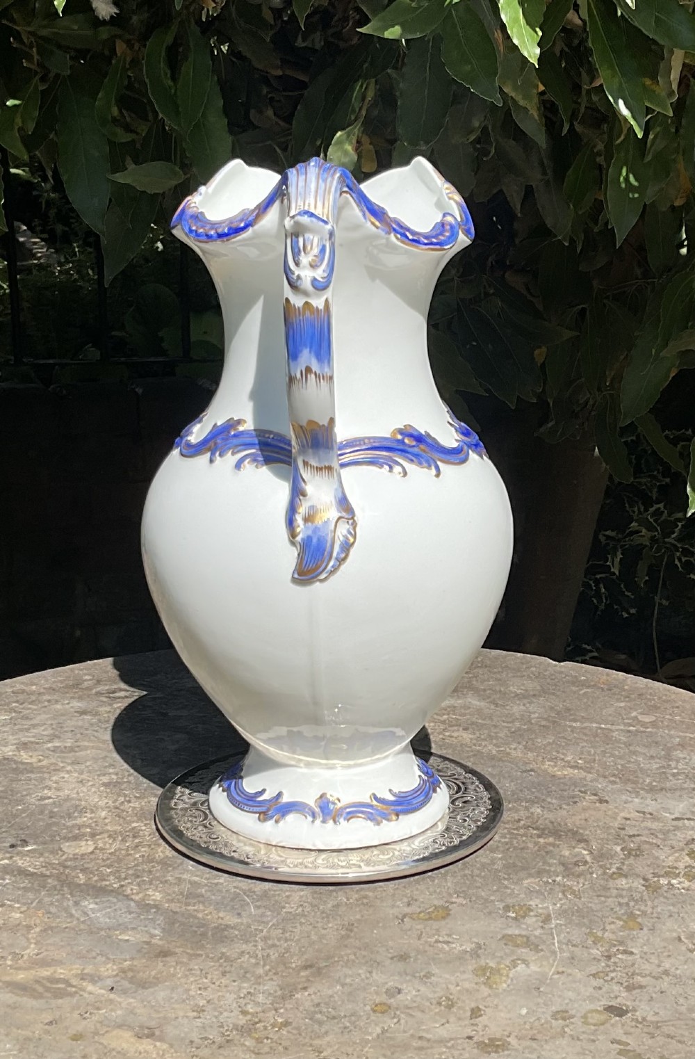 A 19th-century white porcelain water jug featuring cobalt blue foliage mouldings highlighted with gold leaf detailing along the rim, handle, shoulder, and base. View II
