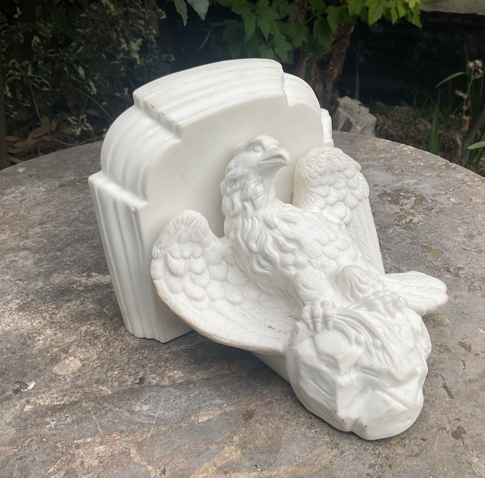 A Victorian off-white Parian porcelain wall bracket featuring a sculpted eagle with outstretched wings perched beneath a stepped shelf ledge. View VI