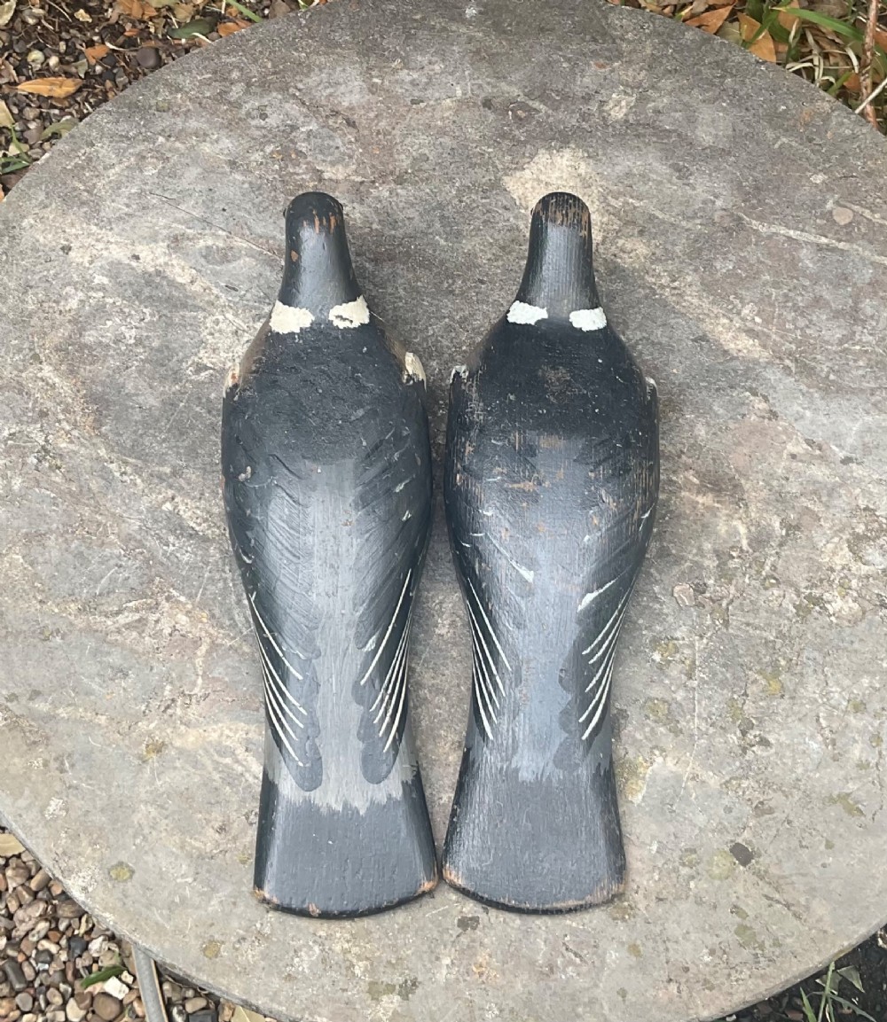 A pair of hand-carved, painted wooden wood pigeon decoys with weathered grey, black, and white plumage. View IV