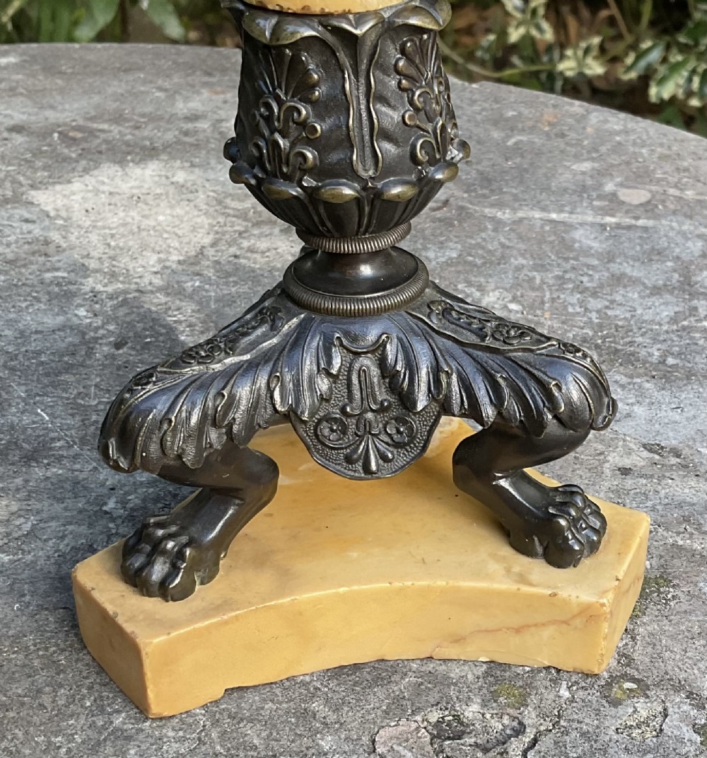 A pair of Regency period candlesticks with yellow marble column stems, classical dark bronze sconces, acanthus collars, and bronze paw feet on triform marble bases. View VI