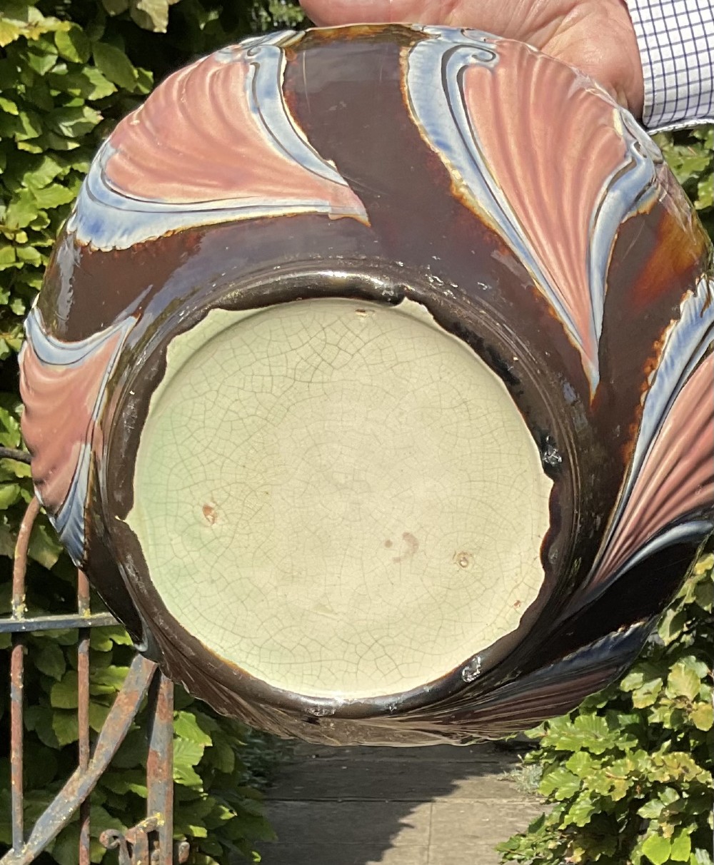 A late Victorian glazed majolica ceramic jardiniere resting atop a matching relief-moulded pedestal stand with brown, blue, and pink glazes. View III