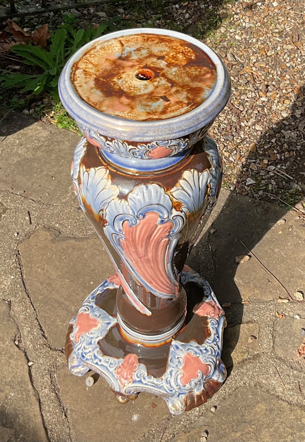 A late Victorian glazed majolica ceramic jardiniere resting atop a matching relief-moulded pedestal stand with brown, blue, and pink glazes. View IV