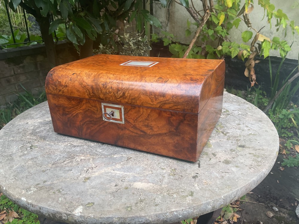 An open Victorian walnut sewing box featuring a fitted purple silk interior and a pleated cream silk panel on the inside lid. View IV