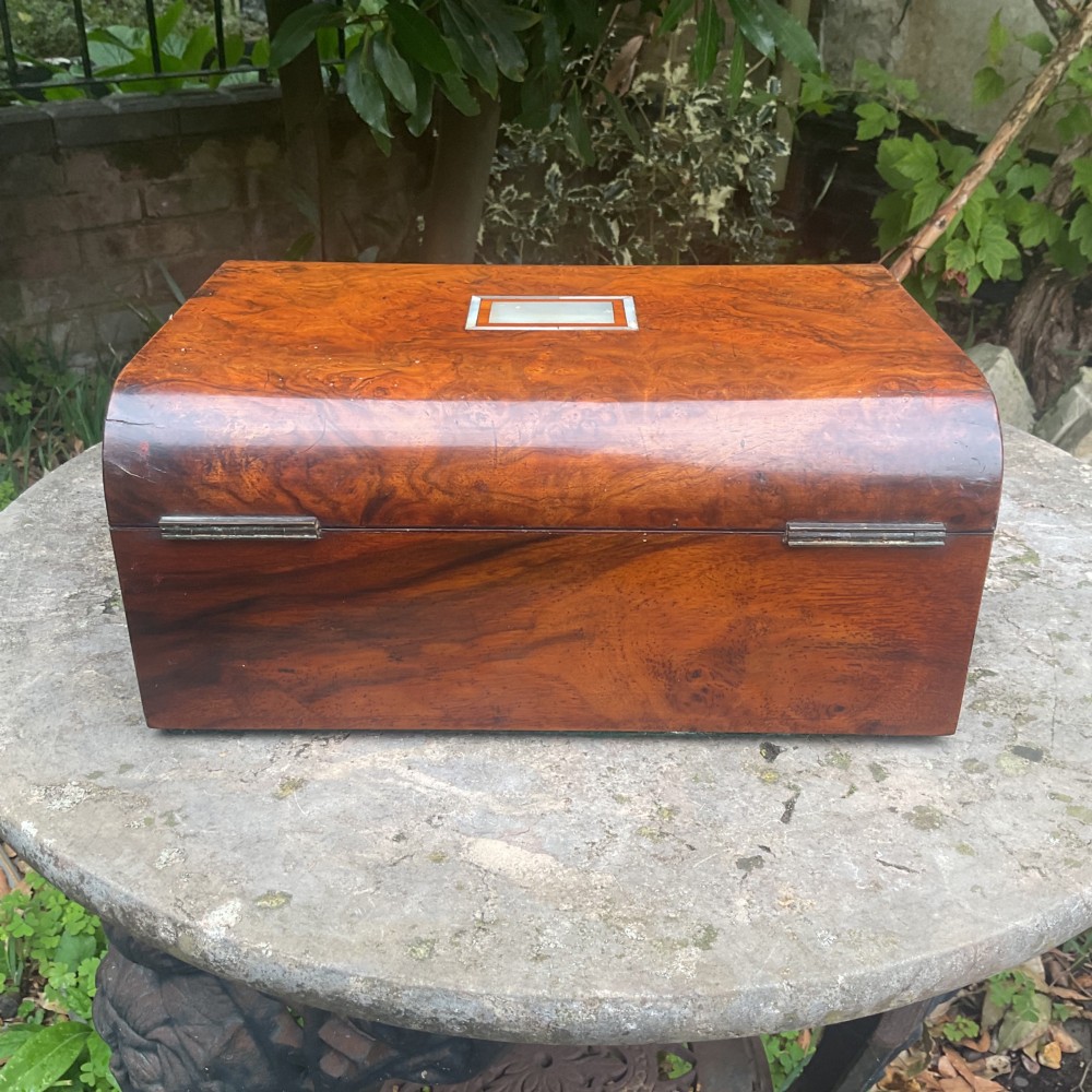 An open Victorian walnut sewing box featuring a fitted purple silk interior and a pleated cream silk panel on the inside lid. View VII
