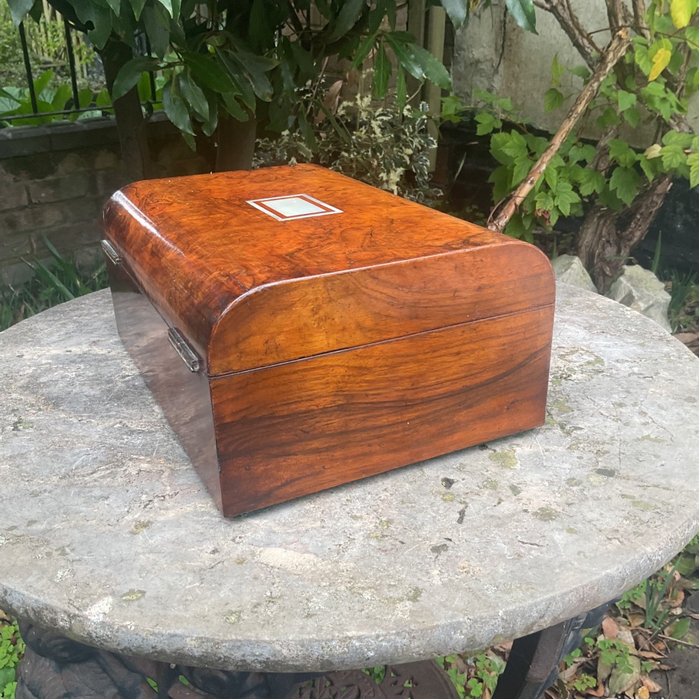 An open Victorian walnut sewing box featuring a fitted purple silk interior and a pleated cream silk panel on the inside lid. View VIII