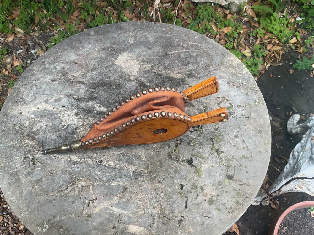 A Regency-period hand-painted wooden fire bellows featuring a painted landscape scene, brass nozzle, tan leather sides, and decorative brass studs. View V