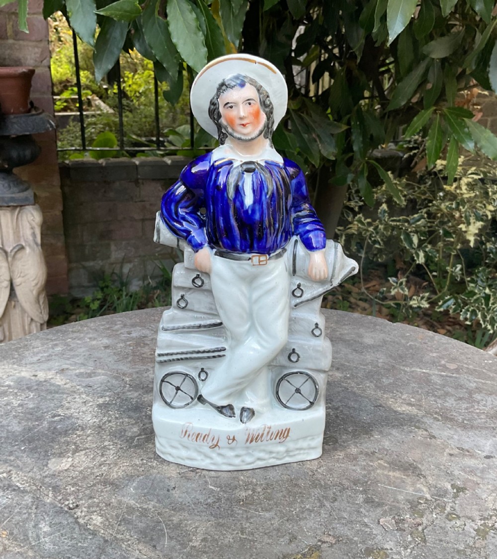 A Victorian Staffordshire earthenware figure depicting an English sailor leaning on a cannon with the base inscribed Ready and Willing.
