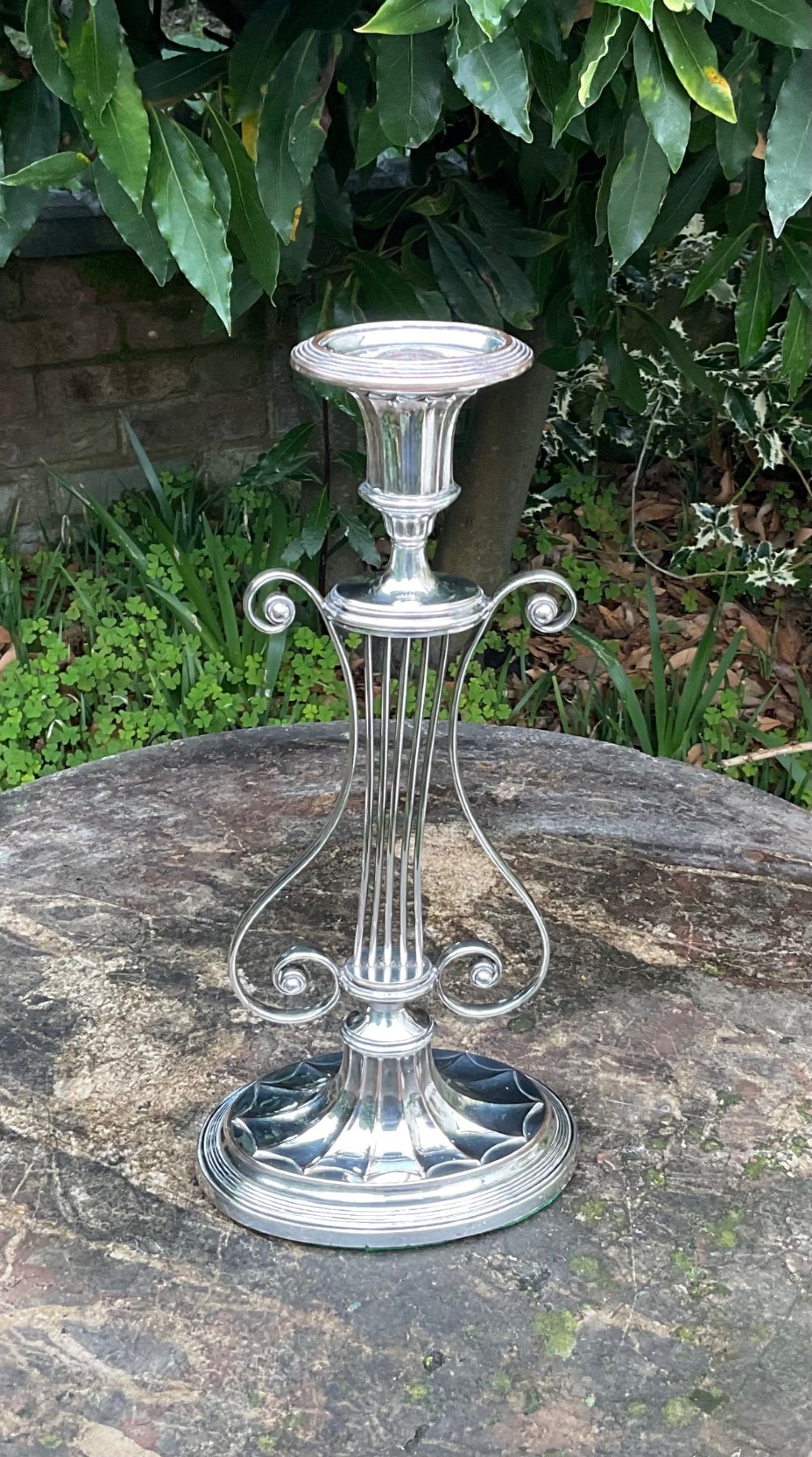A tall silver-plated candlestick designed in the Adam style featuring a lyre-shaped central column, scroll motifs, and a fluted sconce over a circular moulded base. View III