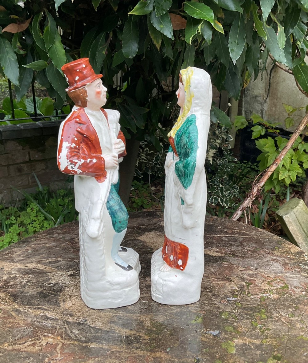 A pair of late Victorian Staffordshire earthenware flatback figures depicting an Irish piper in a red coat and an Irish colleen wearing a yellow headscarf. View IV
