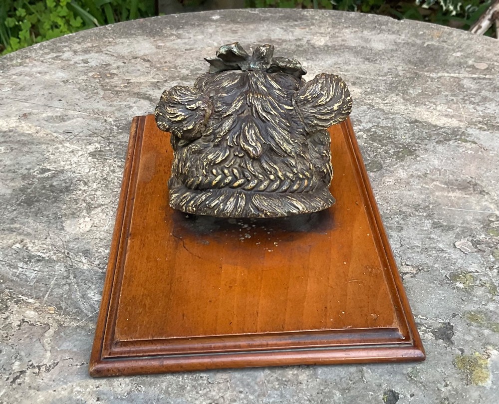 An antique Austrian cold-painted bronze head of a Yorkshire Terrier with a green bow, mounted on a rectangular timber base as a spring paper clip. View IV