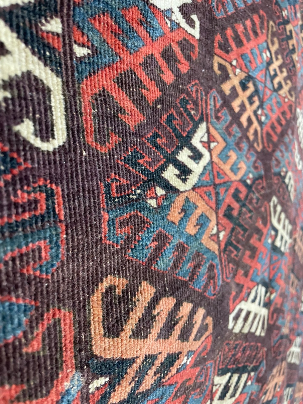 An antique Yomut Turkoman hand-knotted wool rug featuring repeating geometric diamond lattice motifs in deep red, navy blue, and ivory shades. View III