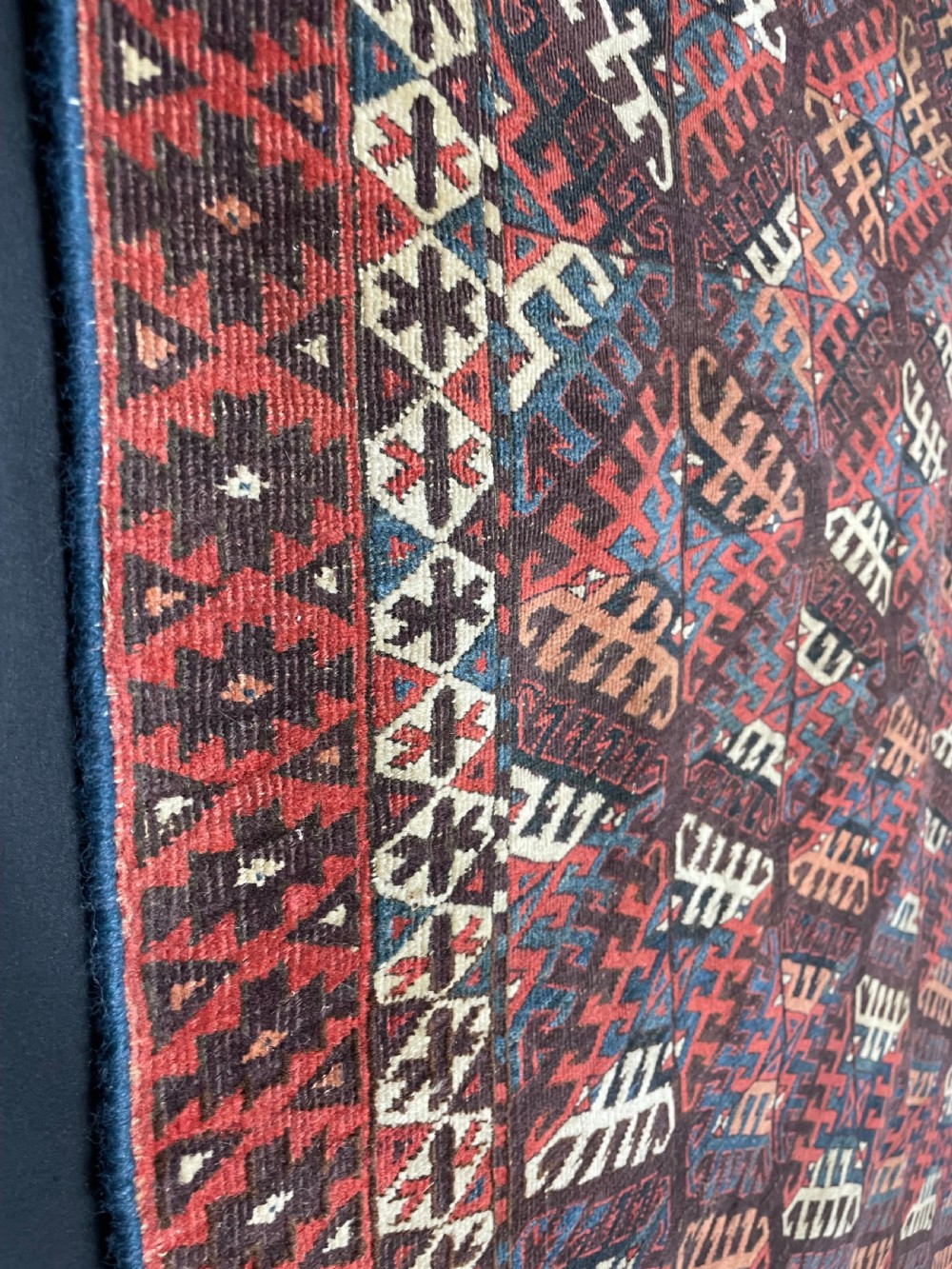An antique Yomut Turkoman hand-knotted wool rug featuring repeating geometric diamond lattice motifs in deep red, navy blue, and ivory shades. View VII