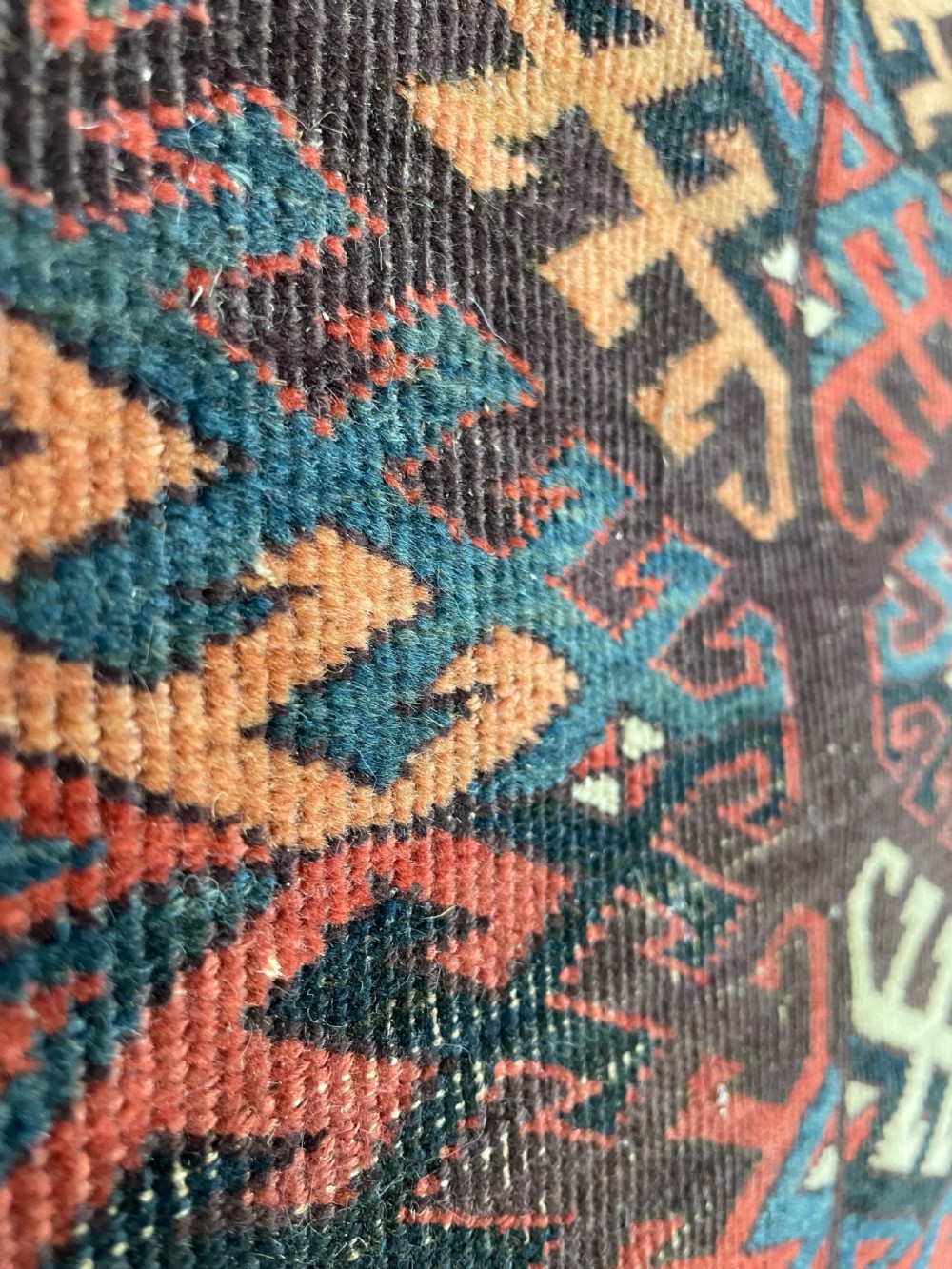 An antique Yomut Turkoman hand-knotted wool rug featuring repeating geometric diamond lattice motifs in deep red, navy blue, and ivory shades. View X