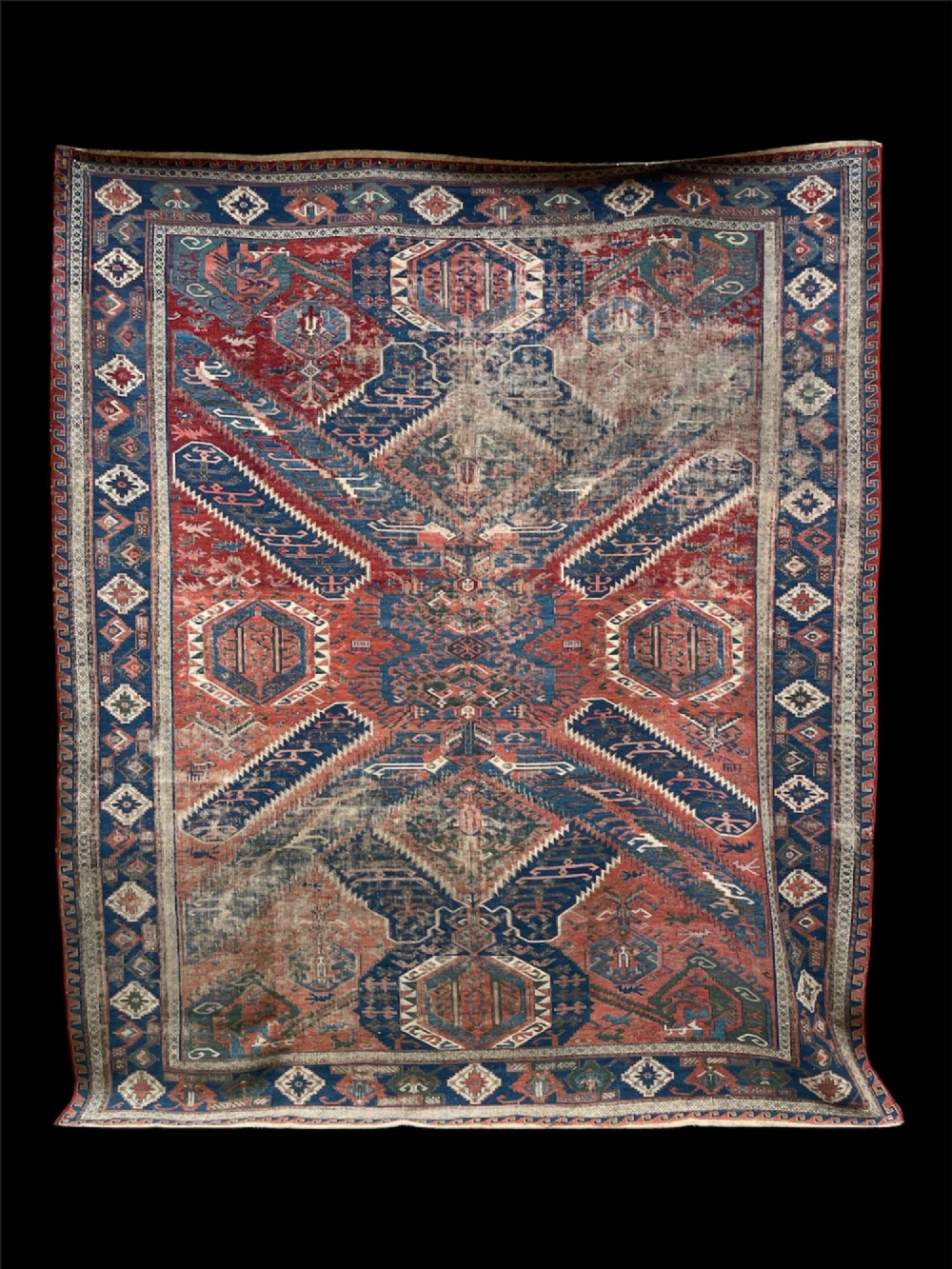 An antique Caucasian Dragon Soumak flatweave wool rug featuring geometric diamond medallions and dragon motifs in terracotta red, navy blue, and teal green.