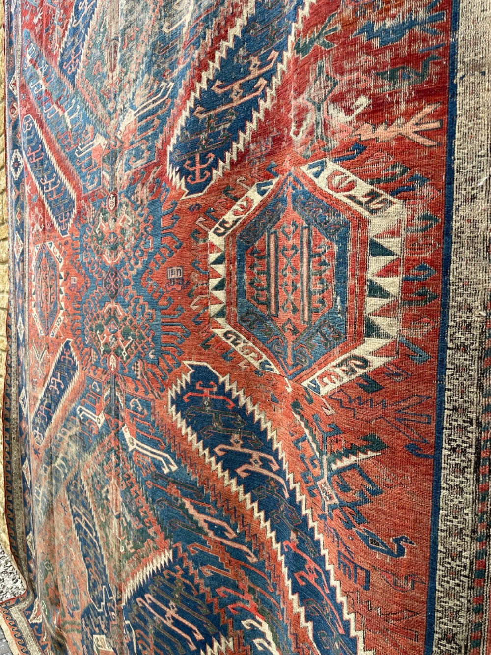 An antique Caucasian Dragon Soumak flatweave wool rug featuring geometric diamond medallions and dragon motifs in terracotta red, navy blue, and teal green. View IV