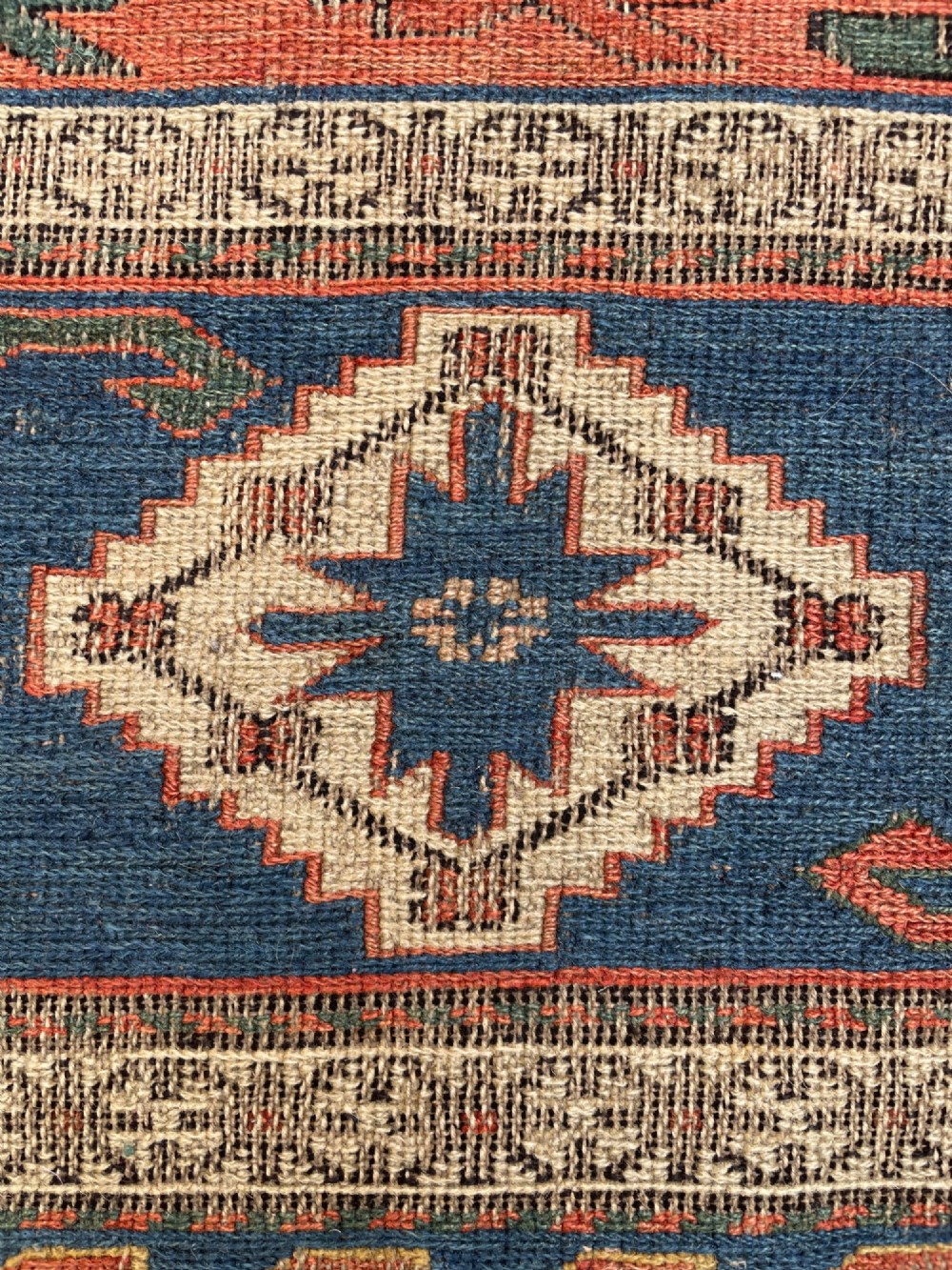 An antique Caucasian Dragon Soumak flatweave wool rug featuring geometric diamond medallions and dragon motifs in terracotta red, navy blue, and teal green. View XI