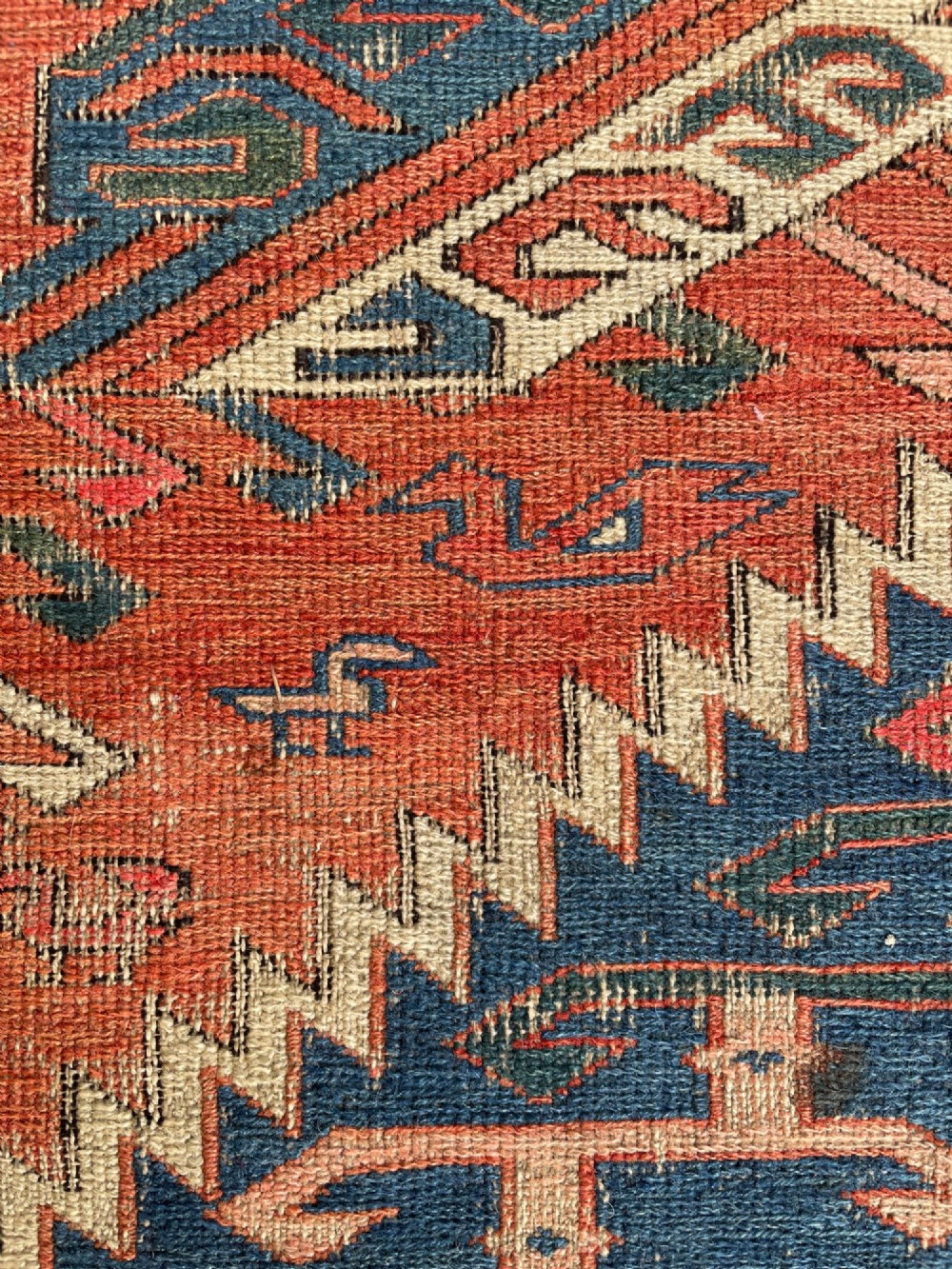 An antique Caucasian Dragon Soumak flatweave wool rug featuring geometric diamond medallions and dragon motifs in terracotta red, navy blue, and teal green. View XIII