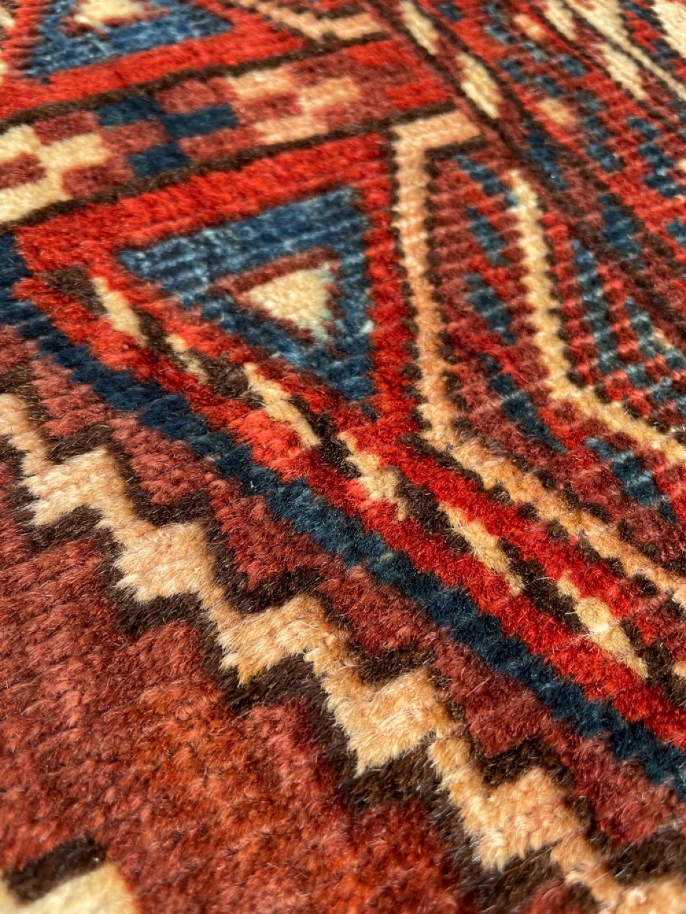 A large antique hand-knotted wool Turkoman Yomut carpet featuring repeating geometric gol motifs on a deep red ground surrounded by geometric borders. View VI