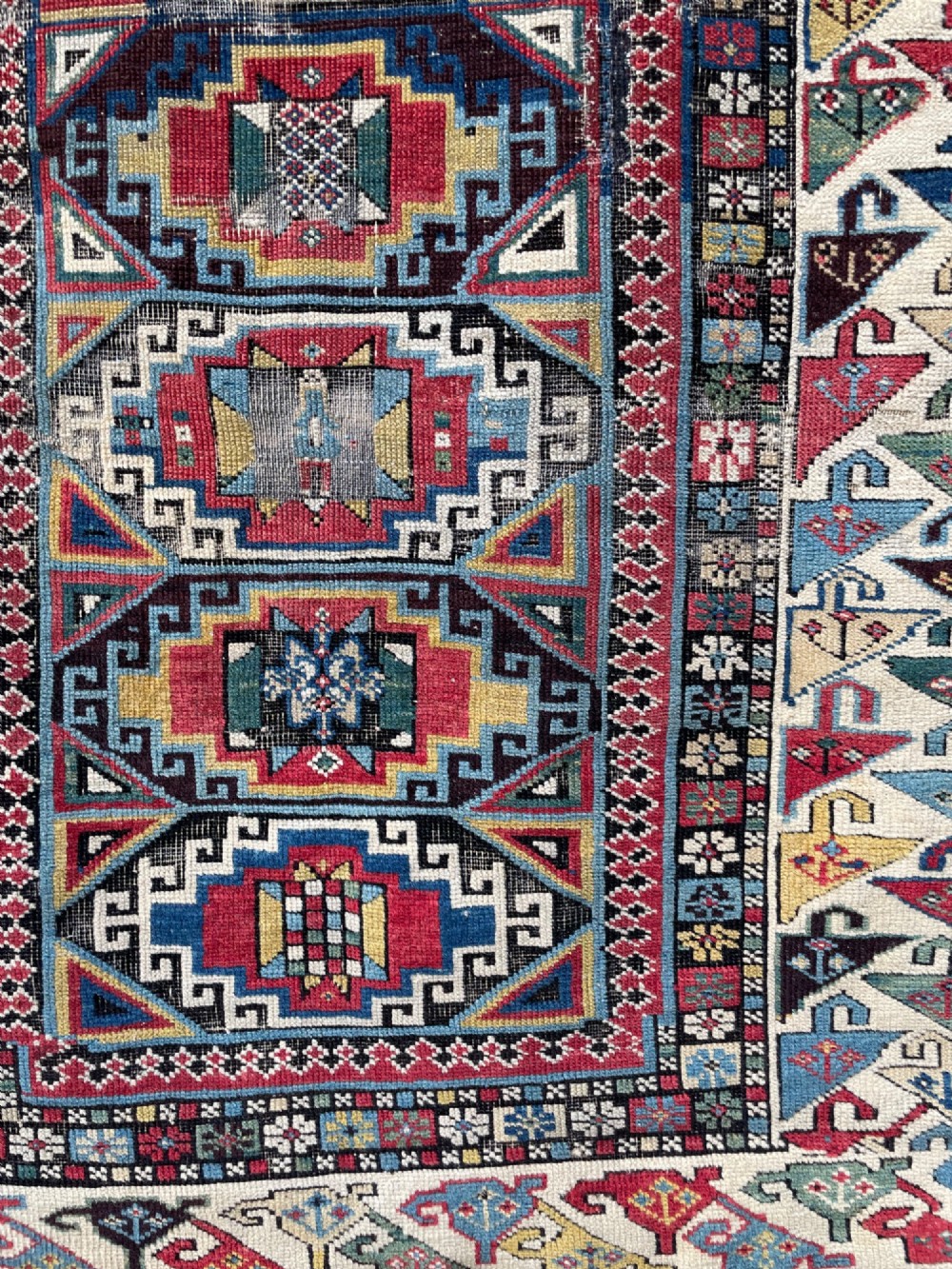 A long hand-knotted wool Shirvan runner rug featuring a central row of geometric stepped medallions framed by detailed multi-coloured bird and hook borders. View III