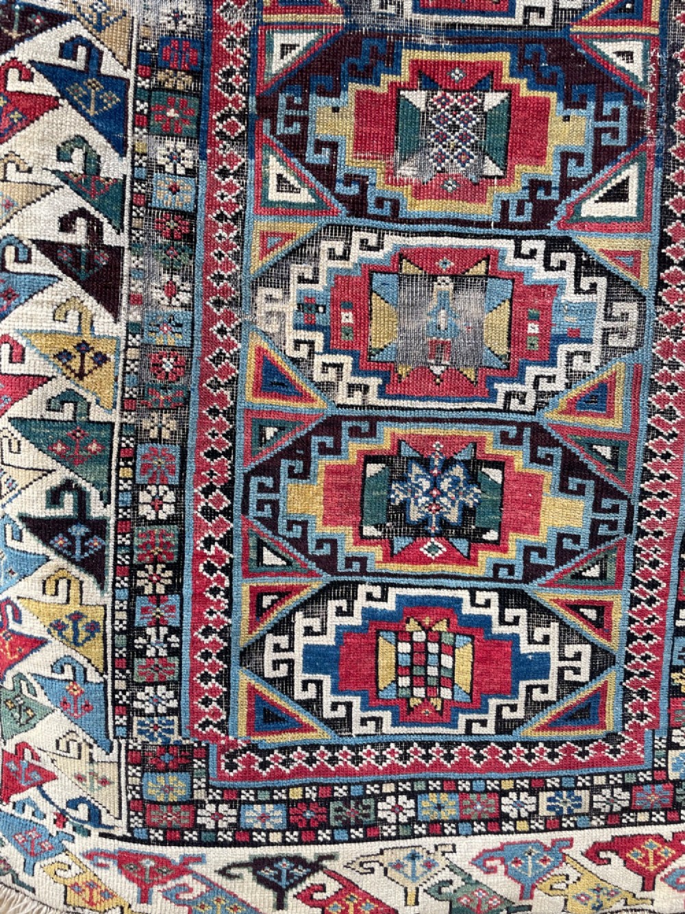 A long hand-knotted wool Shirvan runner rug featuring a central row of geometric stepped medallions framed by detailed multi-coloured bird and hook borders. View IV