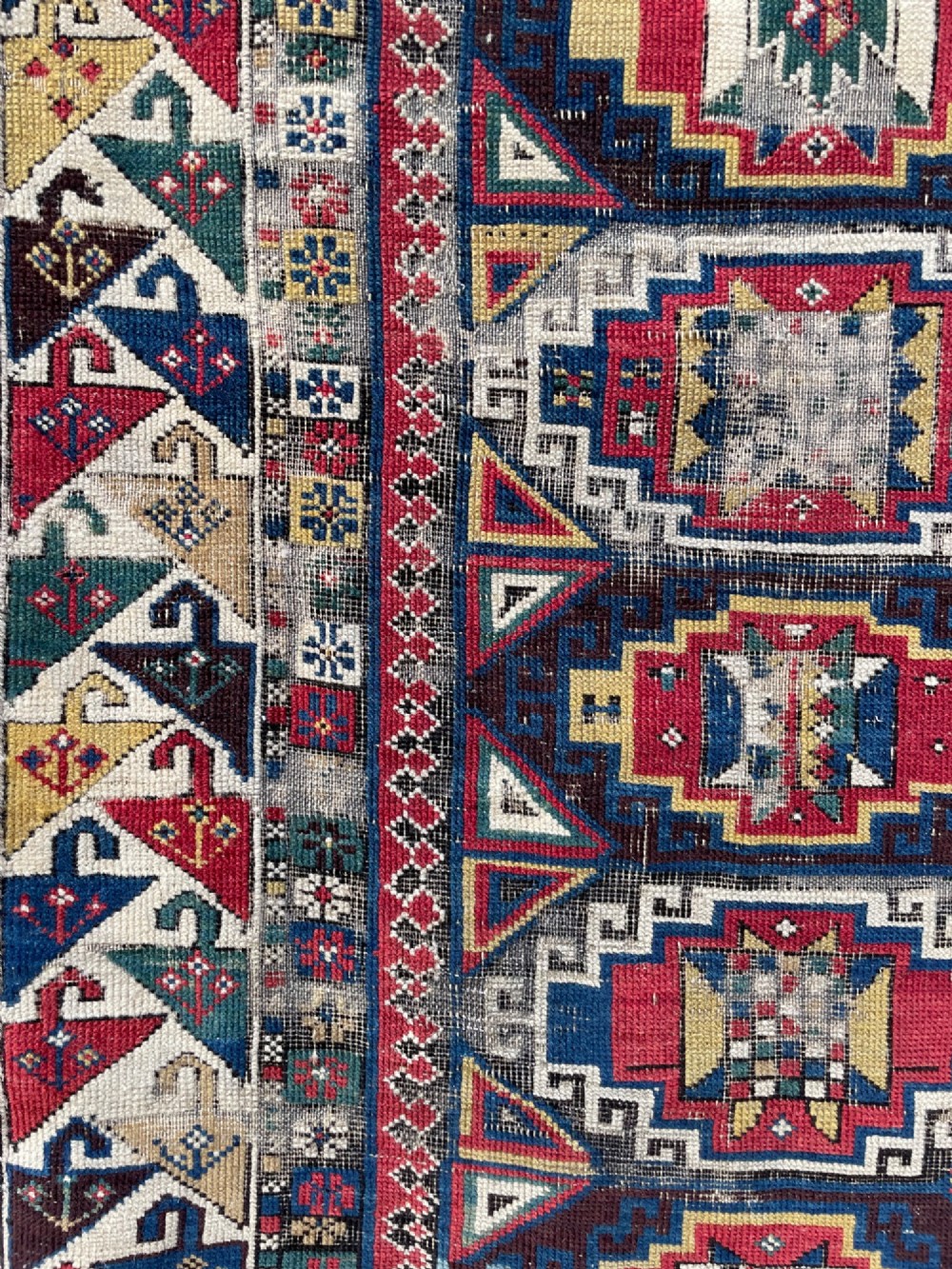 A long hand-knotted wool Shirvan runner rug featuring a central row of geometric stepped medallions framed by detailed multi-coloured bird and hook borders. View VI