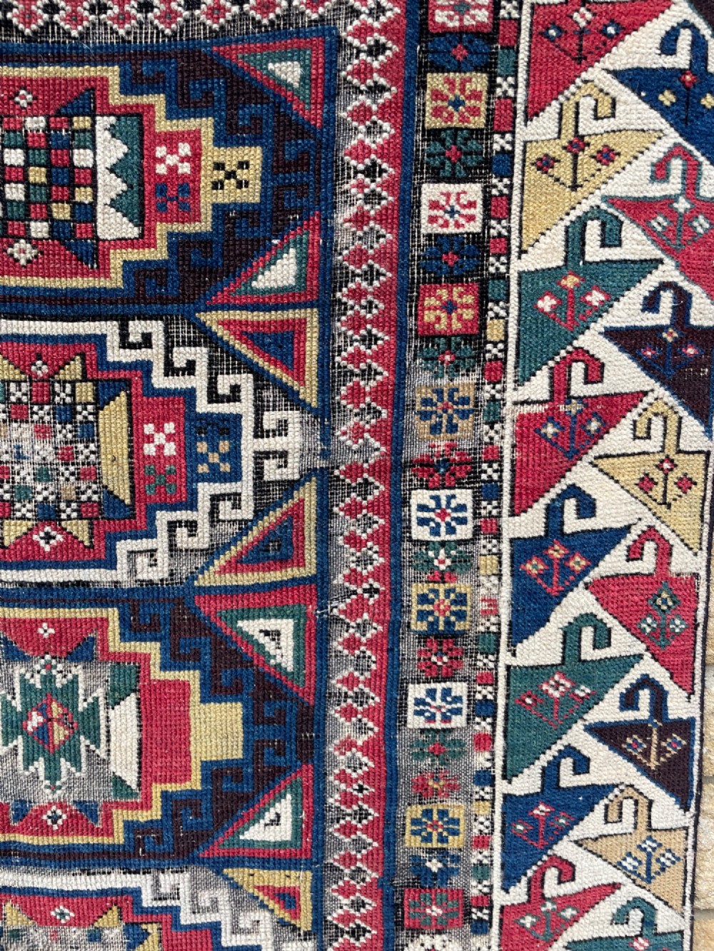 A long hand-knotted wool Shirvan runner rug featuring a central row of geometric stepped medallions framed by detailed multi-coloured bird and hook borders. View VII