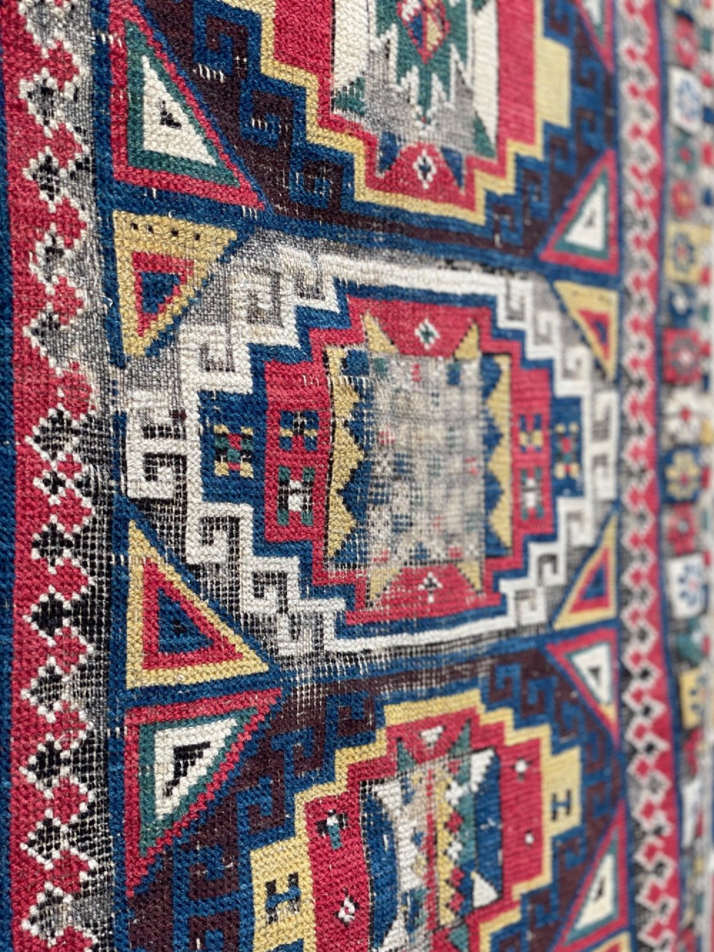 A long hand-knotted wool Shirvan runner rug featuring a central row of geometric stepped medallions framed by detailed multi-coloured bird and hook borders. View VIII