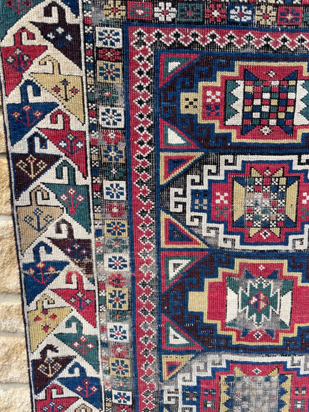 A long hand-knotted wool Shirvan runner rug featuring a central row of geometric stepped medallions framed by detailed multi-coloured bird and hook borders. View X