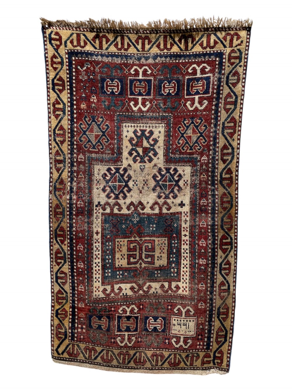 An antique Caucasian Fachralo wool prayer rug featuring a central red field, an ivory geometric mihrab arch, and traditional patterned borders. View II