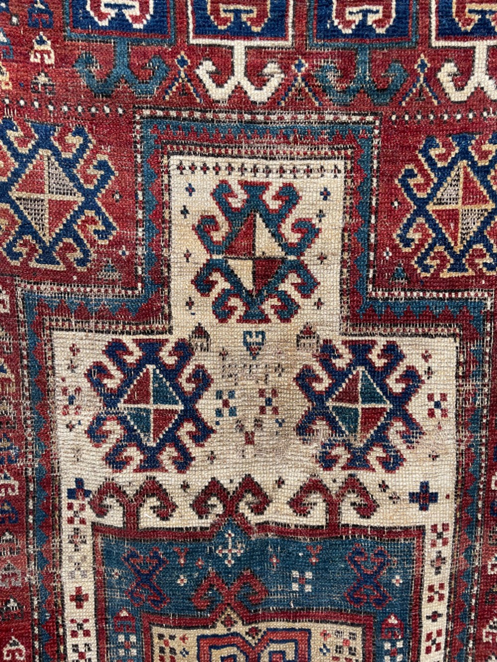 An antique Caucasian Fachralo wool prayer rug featuring a central red field, an ivory geometric mihrab arch, and traditional patterned borders. View VIII