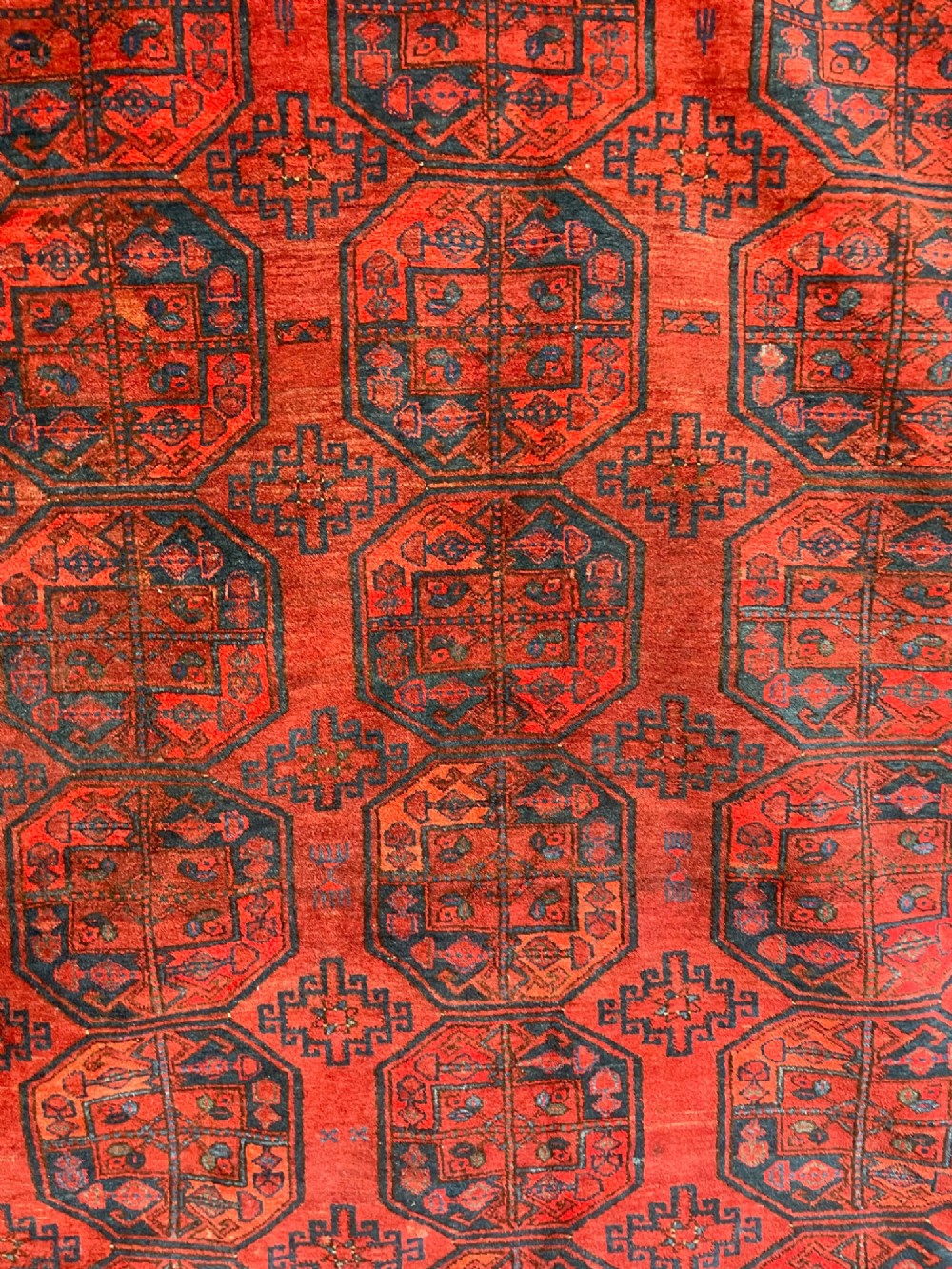 An antique Afghan Ersari hand-knotted wool carpet featuring repeating octagonal gol motifs on a deep red field with geometric borders. View II