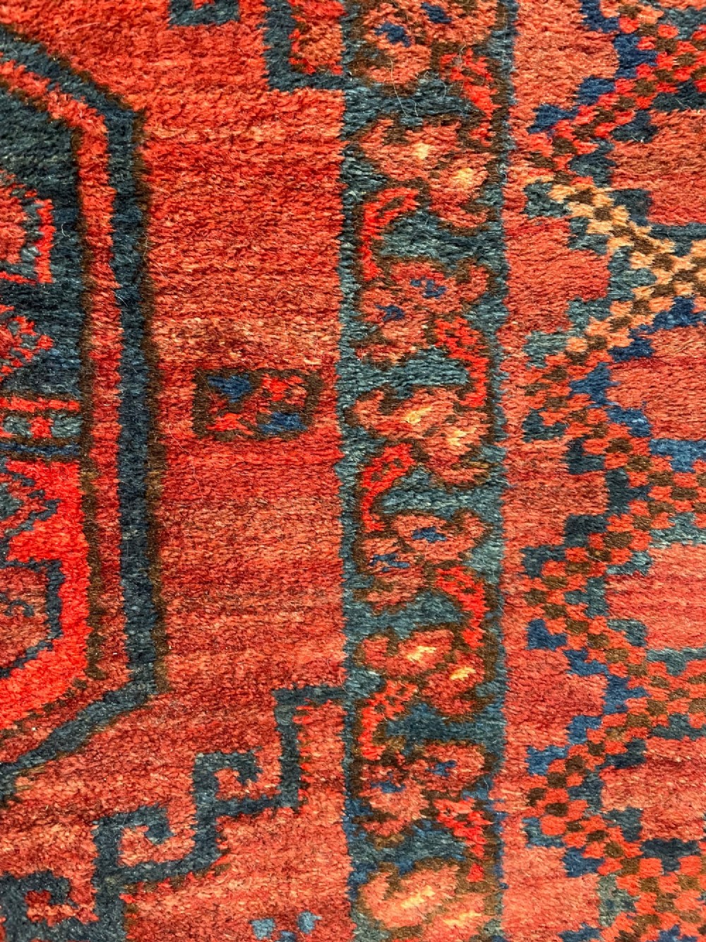 An antique Afghan Ersari hand-knotted wool carpet featuring repeating octagonal gol motifs on a deep red field with geometric borders. View III