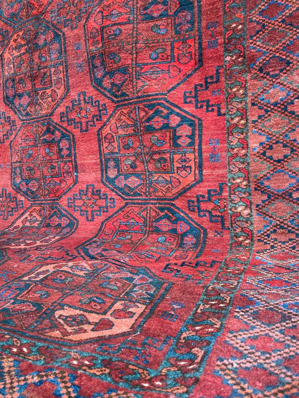 An antique Afghan Ersari hand-knotted wool carpet featuring repeating octagonal gol motifs on a deep red field with geometric borders. View IV