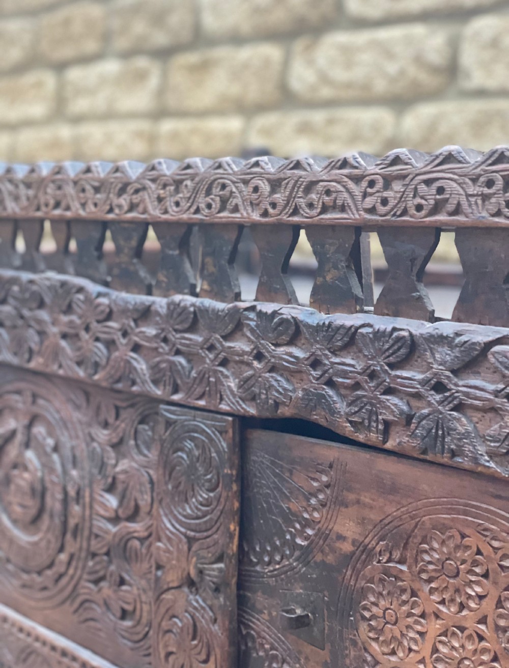 A hand-carved dark wood Swat Valley dowry chest featuring geometric rosettes, corner posts, and an open lattice gallery along the top edge. View VI