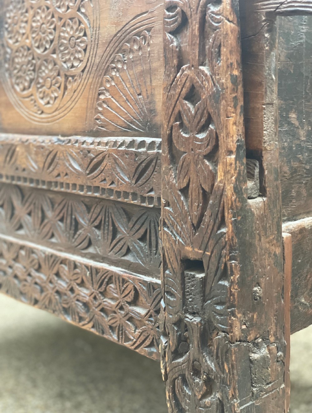 A hand-carved dark wood Swat Valley dowry chest featuring geometric rosettes, corner posts, and an open lattice gallery along the top edge. View VII