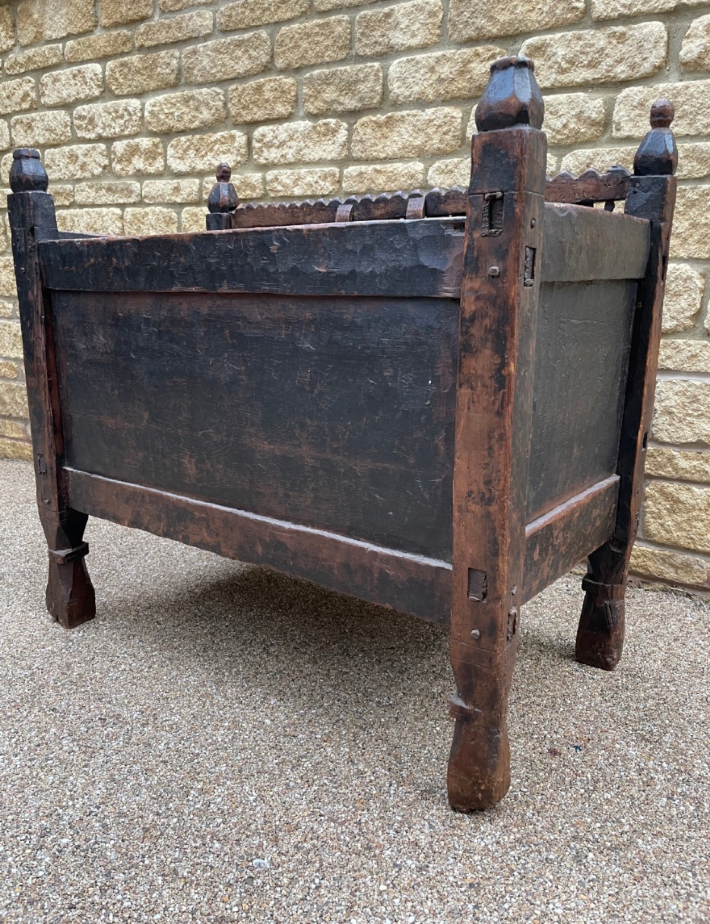 A hand-carved dark wood Swat Valley dowry chest featuring geometric rosettes, corner posts, and an open lattice gallery along the top edge. View X
