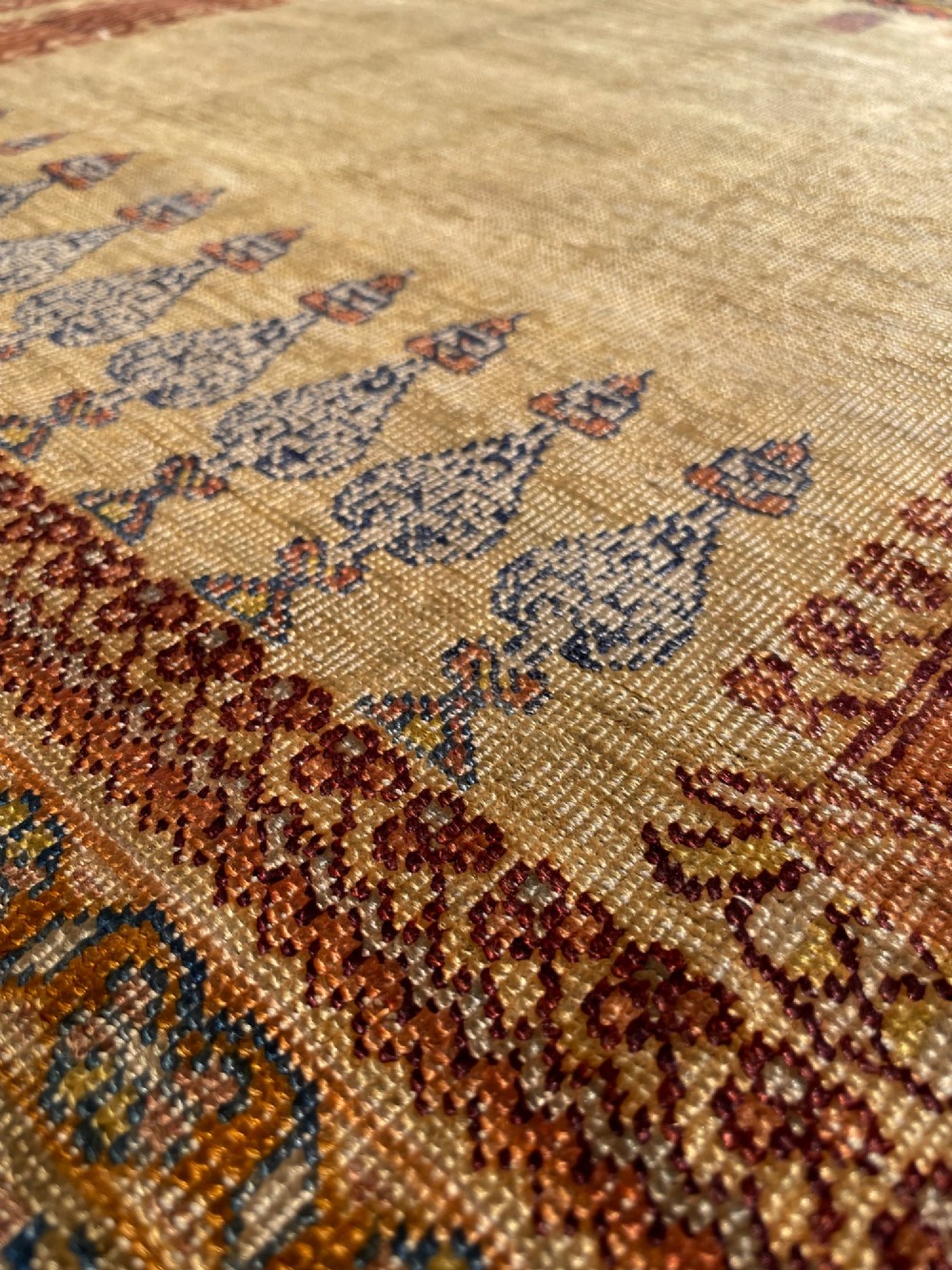 A 19th-century Anatolian silk prayer rug featuring a central gold niche with a hanging lamp motif, enclosed by navy blue and crimson floral borders. View IV