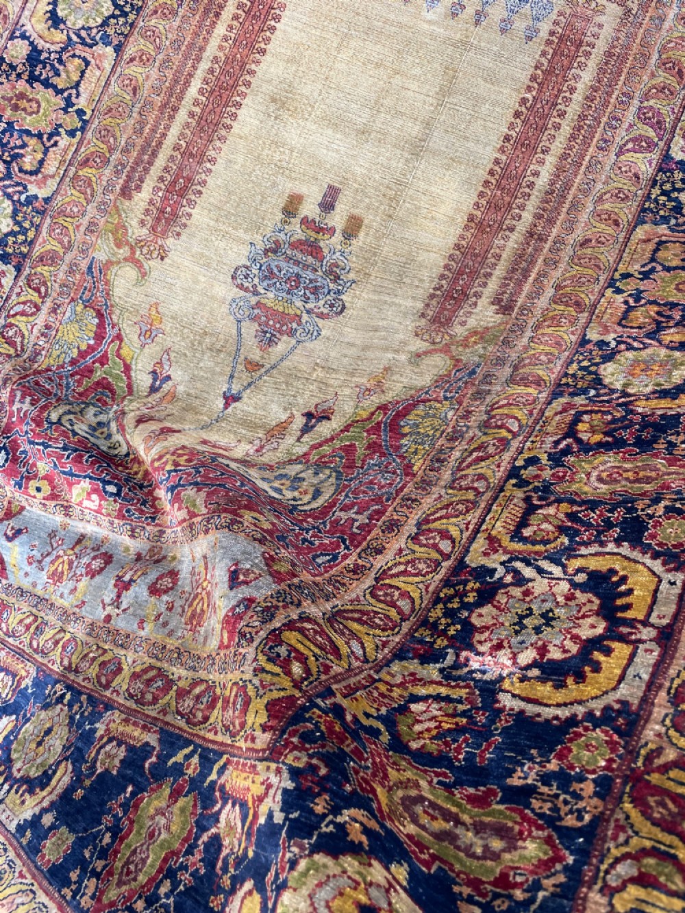 A 19th-century Anatolian silk prayer rug featuring a central gold niche with a hanging lamp motif, enclosed by navy blue and crimson floral borders. View VI