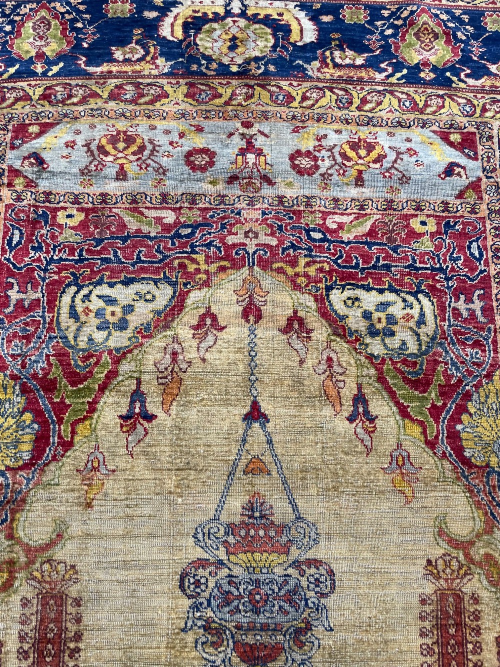 A 19th-century Anatolian silk prayer rug featuring a central gold niche with a hanging lamp motif, enclosed by navy blue and crimson floral borders. View VIII